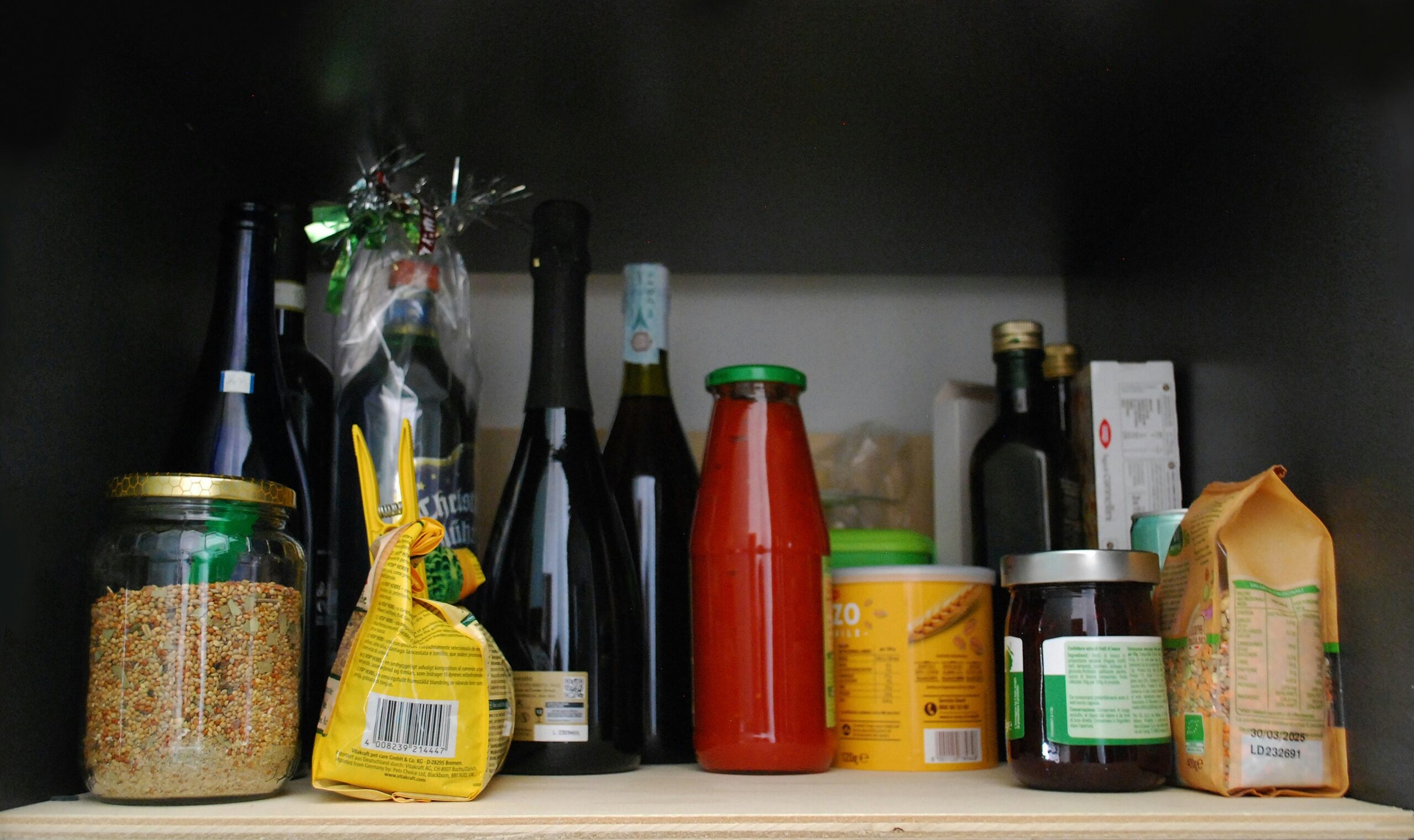 a shelf filled with lots of bottles and condiments